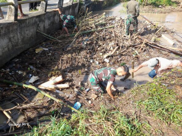 Koptu Hasan Babinsa Koramil 0602-09/Cikeusal Bersama Warga Bersihkan Sampah Yang Menutupi Aliran Sungai