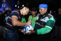 AHY menandatangani bola milik pengemudi ojek online saat menghadiri nonton bareng semifinal Piala Dunia 2026 Spanyol vs Prancis bersama ratusan driver ojol di Kawasan Parkir Timur GBK, Jakarta