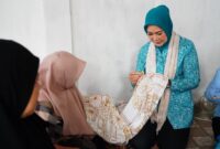 Ketua TP PKK Provinsi Sumsel memegang canting saat mencoba membatik kain berbahan pewarna alami dalam kunjungannya ke Kampung Batik Madani, Kota Lubuk Linggau