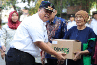 Kepala Dinsos Kota Bekasi saat menyerahkan bantuan
