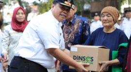 Kepala Dinsos Kota Bekasi saat menyerahkan bantuan
