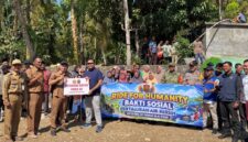Tim Satgaswil DIY Densus 88 Antiteror Polri bersama aparat desa, TNI-Polri, dan warga membentangkan spanduk saat penyerahan bantuan sarana pompa air dan penyaluran air bersih di Kalurahan Kedungpoh