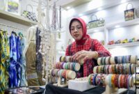 Tinawati Andra Soni melihat dan merapikan koleksi gelang kerajinan khas Banten saat menghadiri Pameran Kerajinan Nusantara (Kriyanusa) 2026 di Jakarta Convention Center