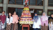Guru dan siswi SMP Taman Dewasa Ibu Pawiyatan berfoto bersama gunungan jajanan di lingkungan sekolah, Yogyakarta