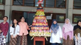 Guru dan siswi SMP Taman Dewasa Ibu Pawiyatan berfoto bersama gunungan jajanan di lingkungan sekolah, Yogyakarta