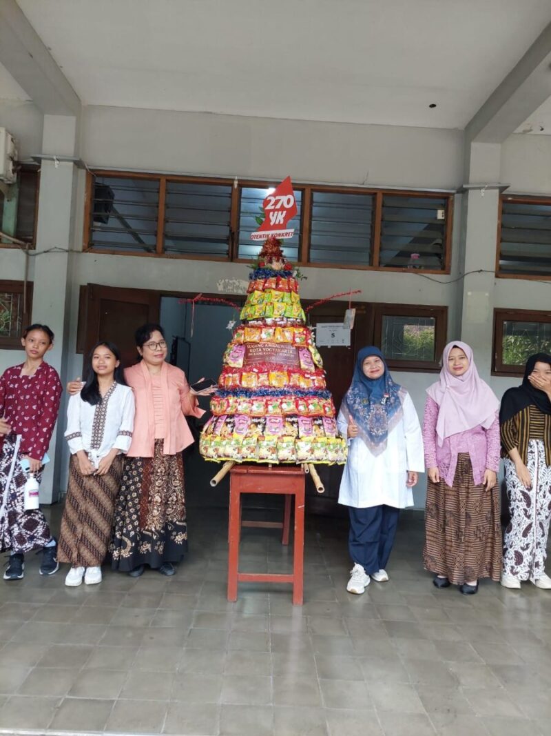 Guru dan siswi SMP Taman Dewasa Ibu Pawiyatan berfoto bersama gunungan jajanan di lingkungan sekolah, Yogyakarta