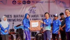 Marindo Kurniawan menyerahkan hadiah doorprize kepada peserta yang beruntung pada puncak Dies Natalis ke-47 Fakultas Teknik Unila.